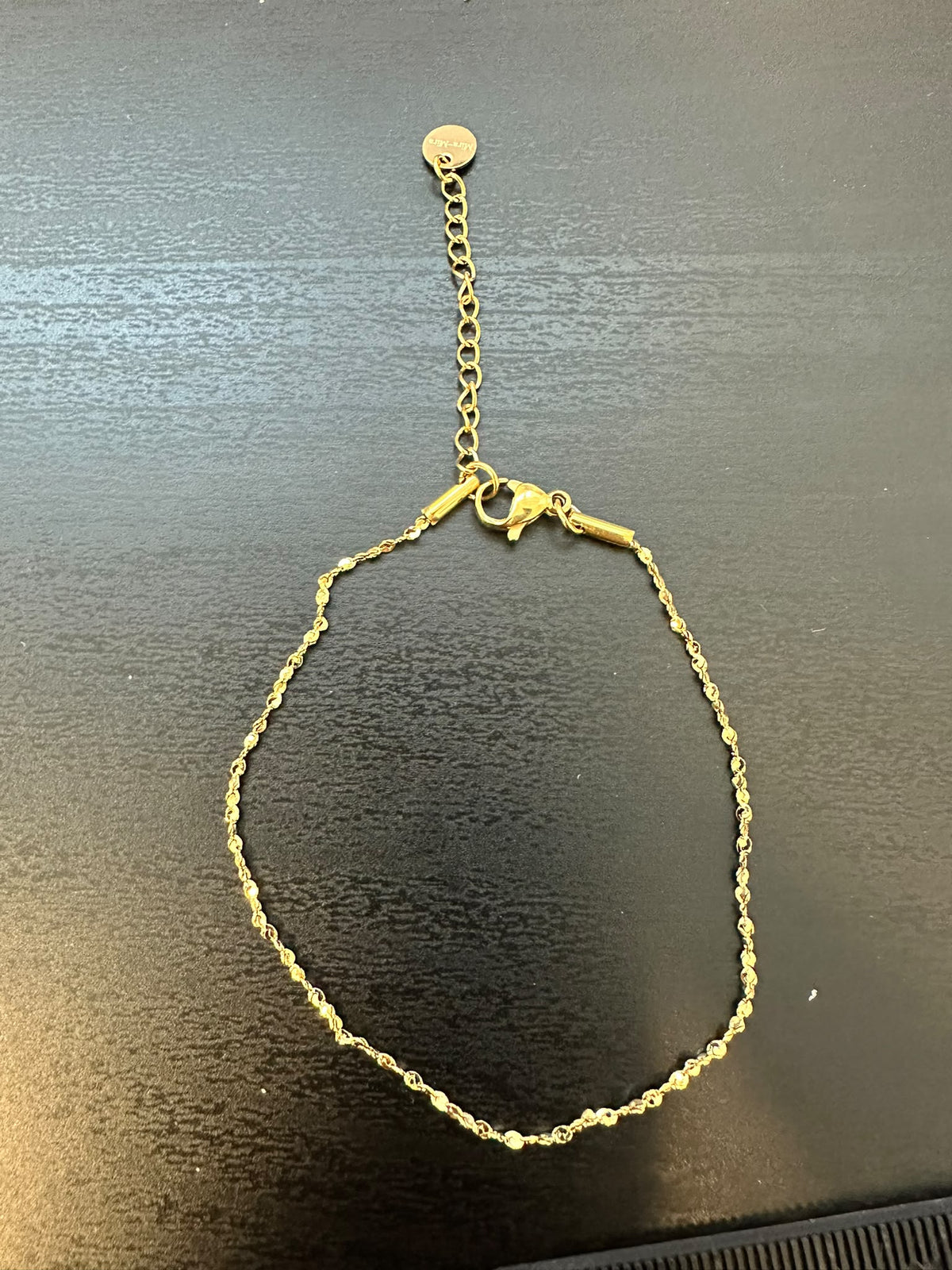 BRACCIALE A MAGLIA COMPOSTA DA PICCOLE PIASTRINE CIRCOLARI CON REGOLAZIONE