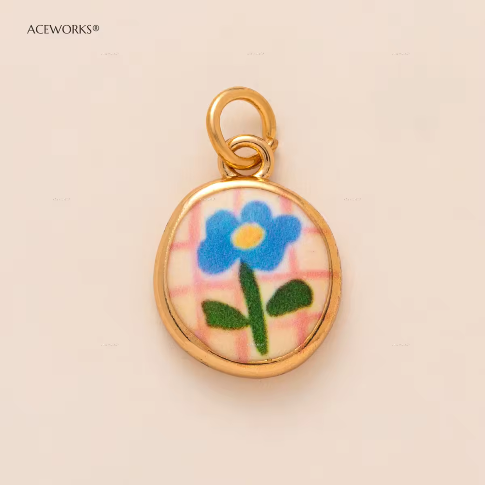 CHARM TONDO FIORE SMALTATO IN ACCIAIO PLACCATO ORO