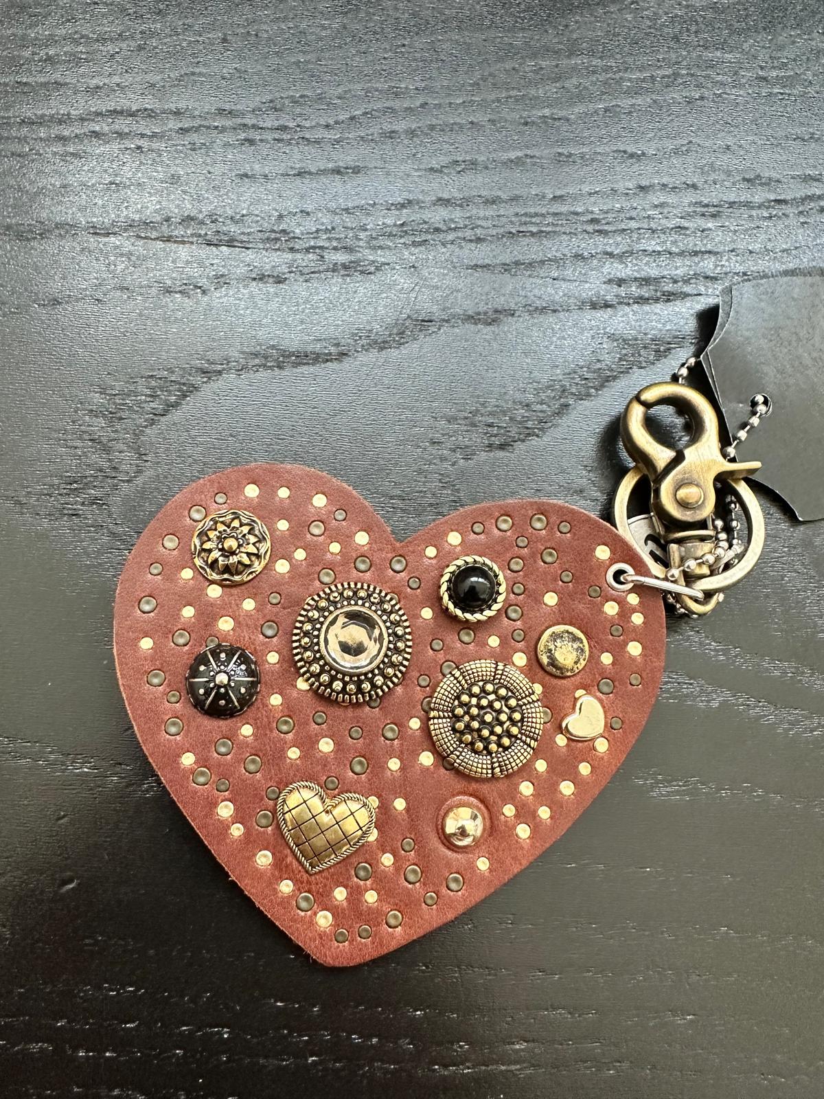 PORTACHIAVI IN PELLE CON SAGOMA A CUORE E BORCHIE DECORATIVE DI VARIO GENERE