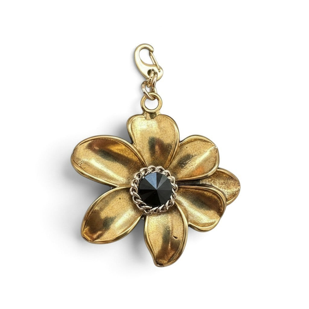 Charm a fiore Fanatikerie in metallo dorato con cristallo nero centrale e moschettone, altezza 5,5 cm.